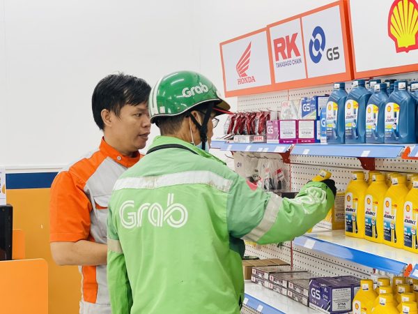 Kỹ thuật viên tại cửa hàng tư vấn thay nhớt cho tài xế Grab