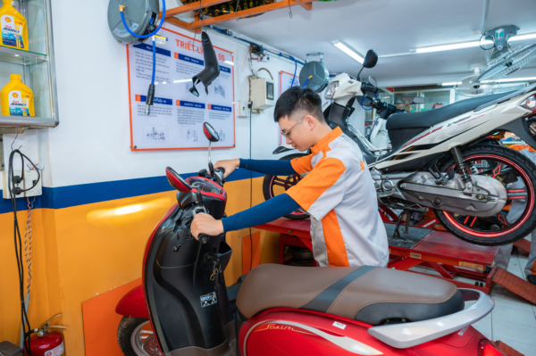 Thợ sửa xe tại True Moto Care kiểm tra tình trạng của xe máy